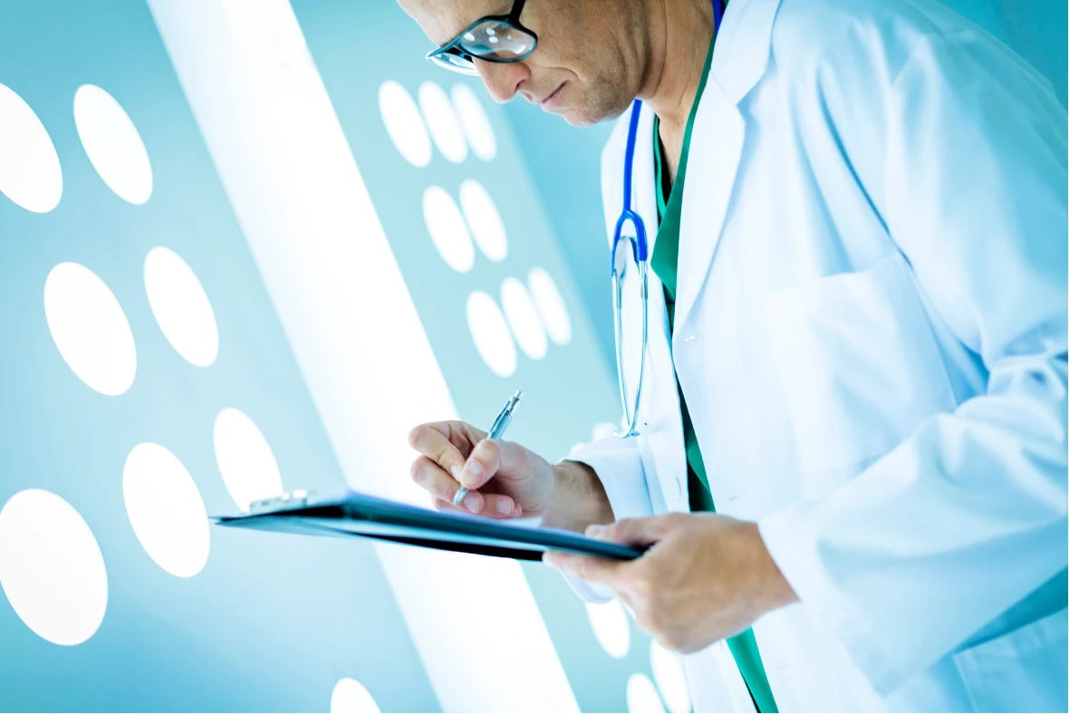 A clinician writing notes on a clipboard